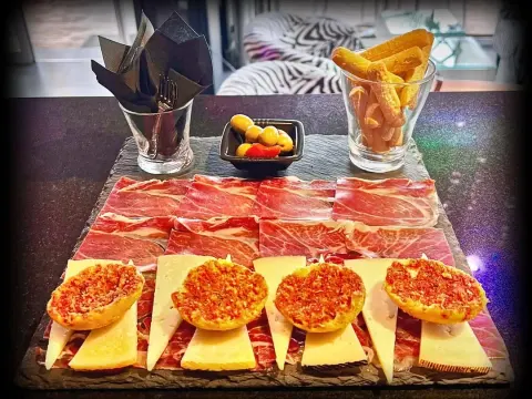 Tabla de jamón ibérico con tostas y patatas fritas