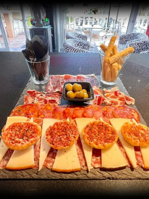 Tabla de jamón con tostas y patatas para compartir