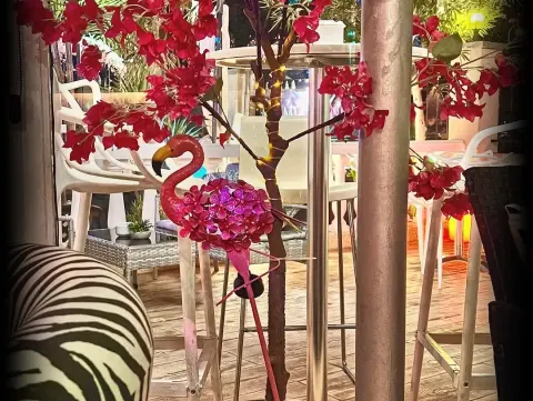 Decoración tropical con flamenco rosa y flores en la terraza