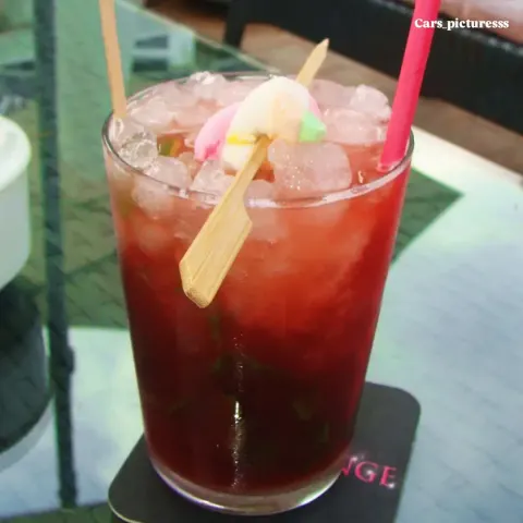 Cóctel rojo de frutas decorado con golosinas
