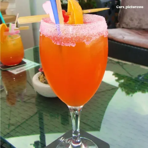 Copa de cóctel naranja con borde de azúcar rosa