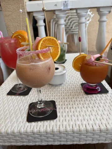 Cócteles con rodajas de naranja y borde de azúcar sobre una mesa de la terraza · Foto de un cliente en Google