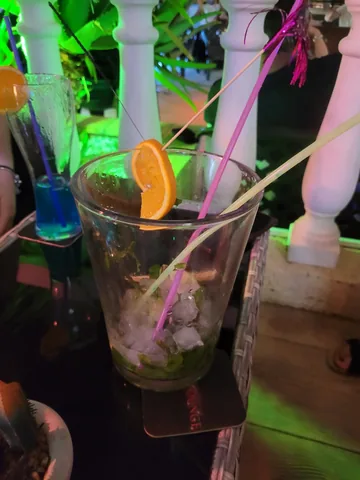 Mojito con rodaja de naranja y menta en la terraza iluminada · Foto de un cliente en Google